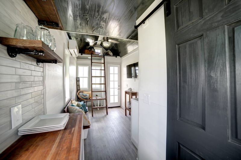 Galley kitchen with open shelving looking toward the loft ladder